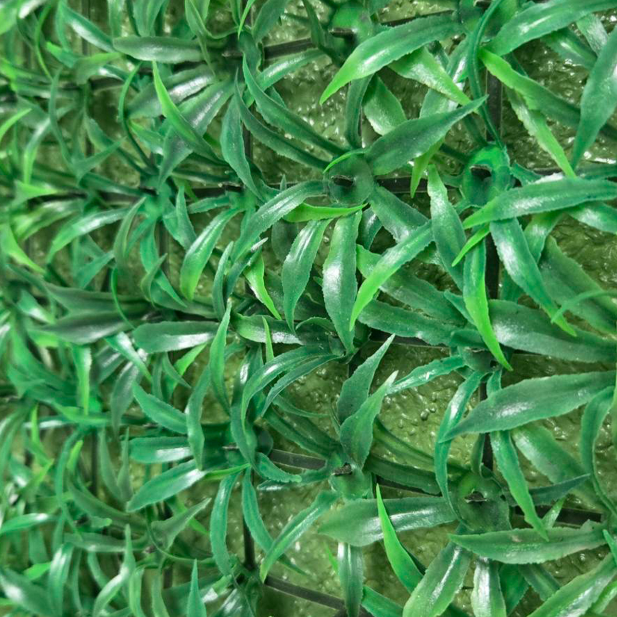 Buseni uskih vlati veštačke trave na crnoj plastičnoj mreži izbliza