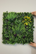 Zidni panel sa paprati i bršljanom 50x50 cm koji drže dve ruke