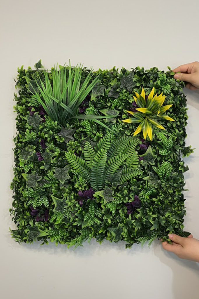 Zidni panel sa paprati i bršljanom 50x50 cm koji drže dve ruke