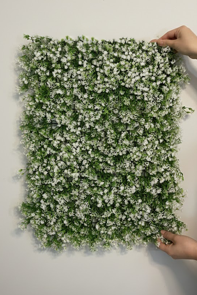 Zidni panel sa sitnim belim cvetićima 60x40 cm koji drže dve ruke